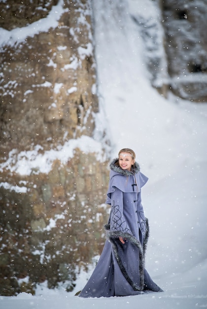 Fairytale elf meisje loopt in de buurt van het oude fort op een winterdag in de sneeuw