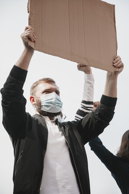 Фото Вера. группа активистов выступает с лозунгами на митинге. кавказские мужчина и женщина вместе маршируют в знак протеста против города. выглядите сердитым, обнадеживающим, уверенным в себе. пустые баннеры для вашего дизайна или рекламы.