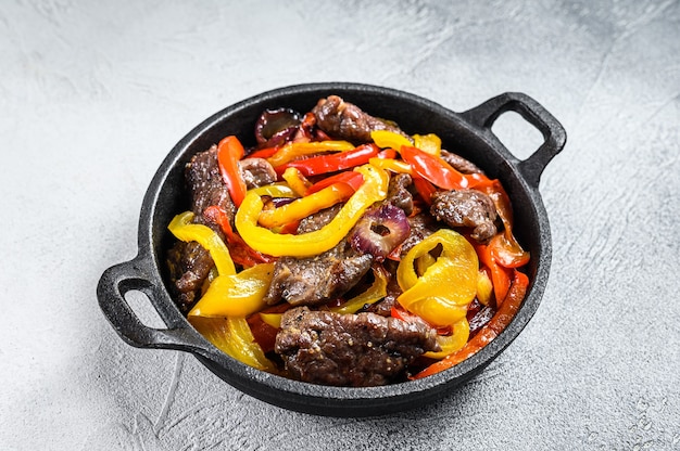 Fajitas beef meat traditional Mexican food dish in a pan. White background. Top view.