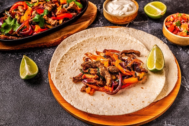 FAJITAS with colored pepper and onions served with tortillas