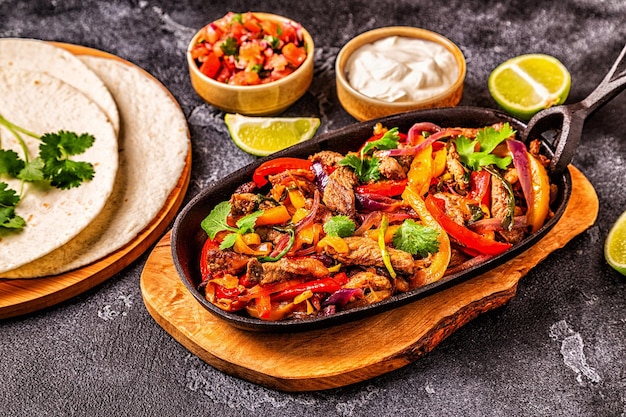 FAJITAS with colored pepper and onions served with tortillas