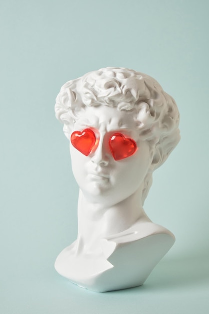 Fake bust of david with red glass hearts on the eyes, love concept, valentine's day congratulations