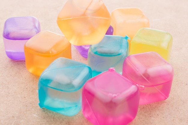 Fake colorful ice cubes on a brown background