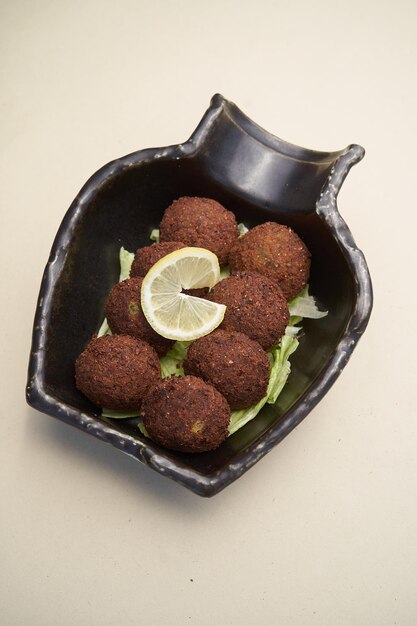 Falafel balls with tzatziki sauce in black plate