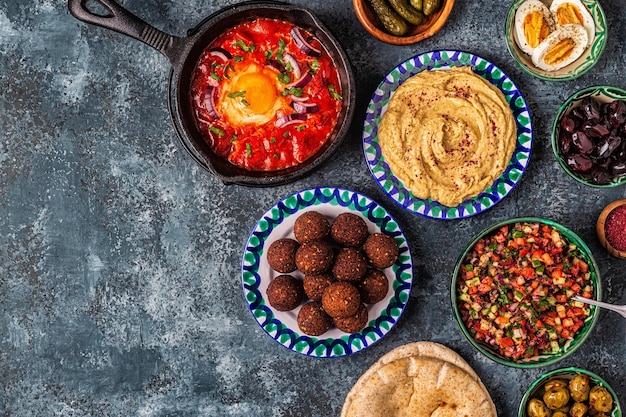 Photo falafel, hummus, shakshuka, israeli salad - traditional dishes of israeli cuisine. top view.