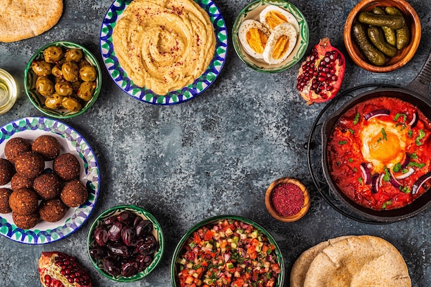 Foto falafel, hummus, shakshuka, insalata israeliana - piatti tradizionali della cucina israeliana. vista dall'alto.