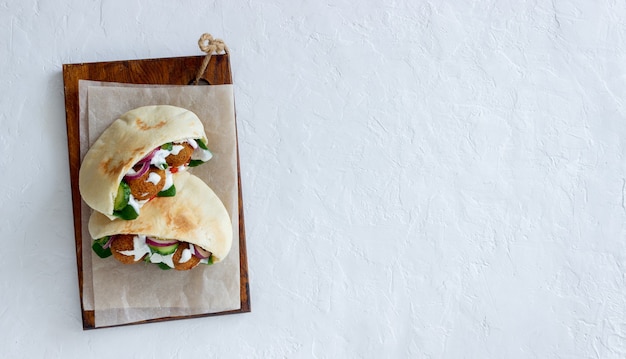 Foto falafel in pitabroodje met tomaten, komkommers, uien en spinazie. gezond eten. vegetarisch eten.