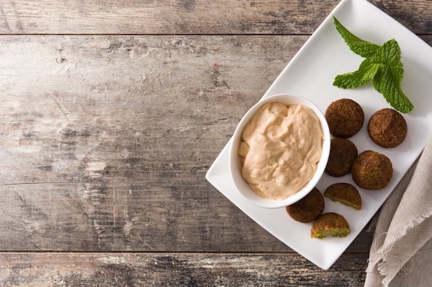 Falafel on a plate on wooden table, top view Copyspace