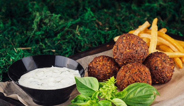 Falafel with french fries on wooden tray