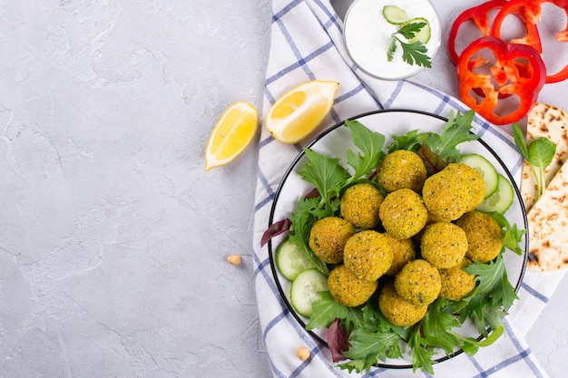 Falafel with pita bread, sauce and salad leaves