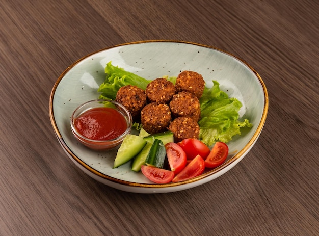 Photo falafel with tomatoes cucumbers and ketchup