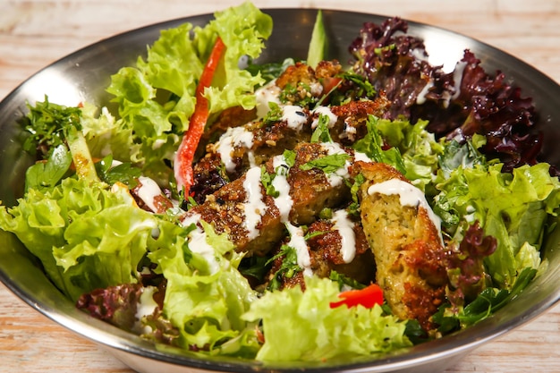 Falafelsalade met slablad geserveerd in kom geïsoleerd op tafelblad van gezond voedsel