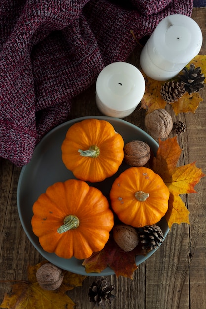 Caduta, ringraziamento di autunno con la zucca arancio nel copyspace di legno piano di disposizione del fondo del piatto rustico