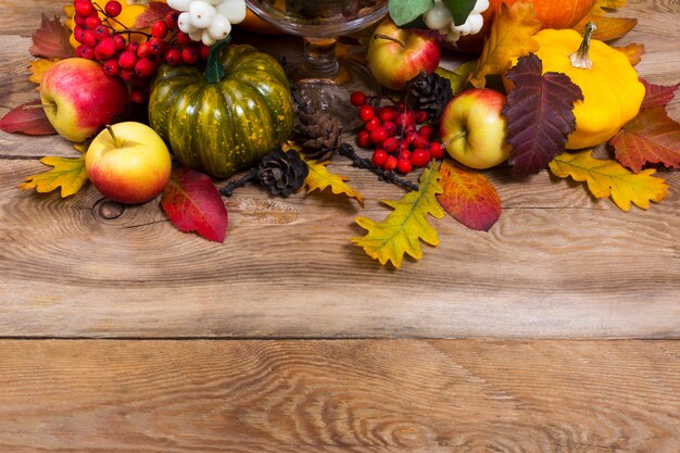 Photo fall background with green pumpkin, yellow squash, oak leaves, copy space