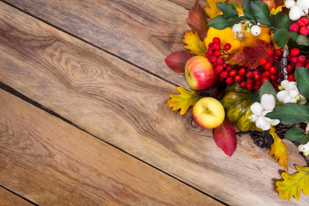 Fall background with snowberry, rowan, apples, leaves and squash, 