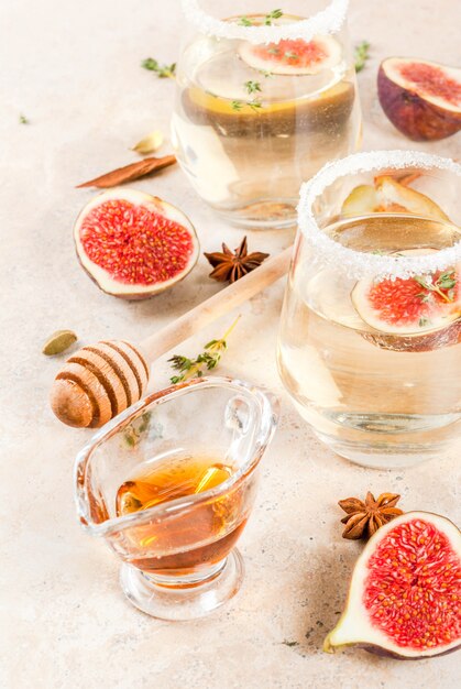 Autunno freddo cocktail di vino bianco dolce con fichi, prugne, miele e timo, copia spazio