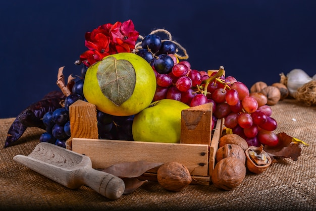 Fall composition with flowers fruits and nuts on a rug background