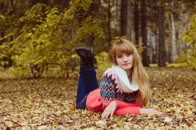 Concetto di caduta - donna di autunno che risiede nel parco