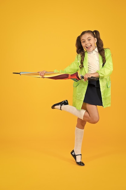 On a fall day Im happy Small kid in rainwear going to school on fall day Little child smiling with bright umbrella protecting her in fall rainy weather Dressing cute and practical in fall