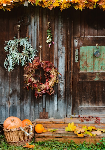 Fall front porch. autumn wreath and pumpkins on old wooden rustic