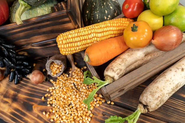 Foto raccolto autunnale e stagione autunnale con frutta e verdura biologica su fondo di legno