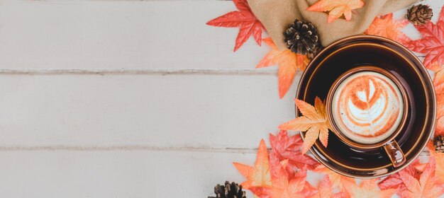 Fall harvest cornucopia. Cup of Hot apple tea for Autumn season warm drink. Copy space on wood background.