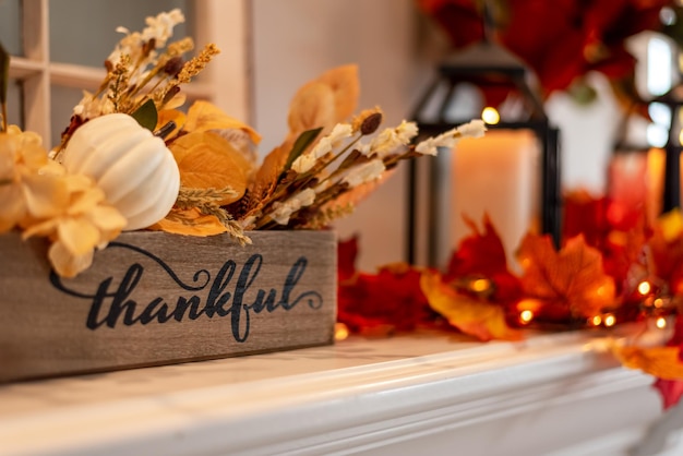 Photo fall holiday mantel decorated with colorful leaves and twinkle lights