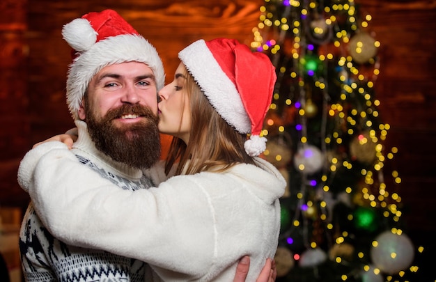 Foto innamorarsi amare i cuori insieme la coppia innamorata si diverte a festeggiare le vacanze di natale tradizione familiare tempo di natale la coppia d'amore abbraccia l'albero di natale sfondio sentimenti romantici