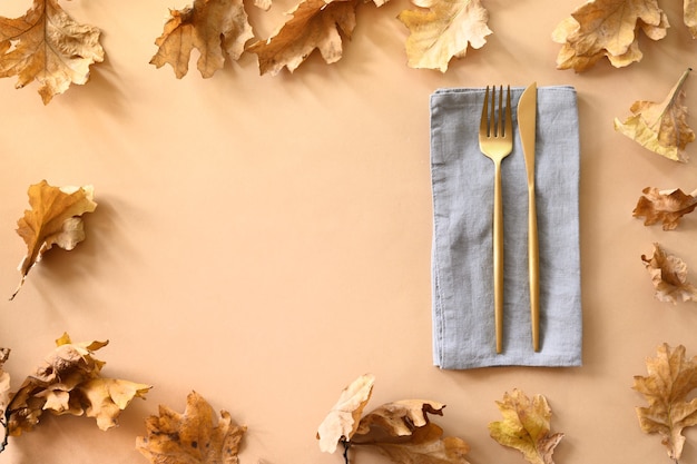 Fall oak leaves and golden cutlery