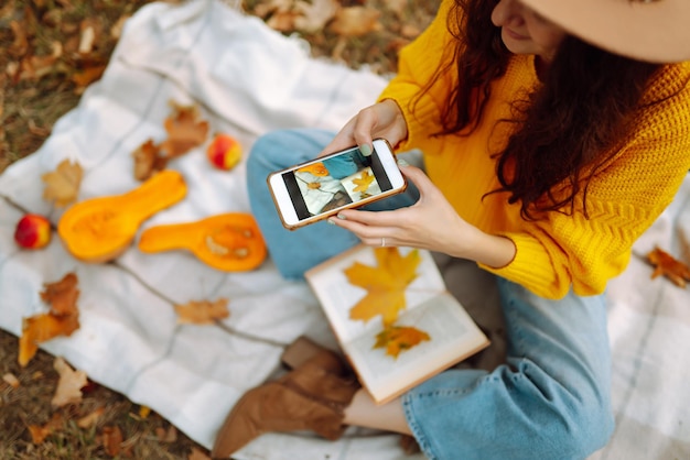 Foto picnic autunnale con zucca donna elegante che gode del clima autunnale nel parco raccolto autunnale