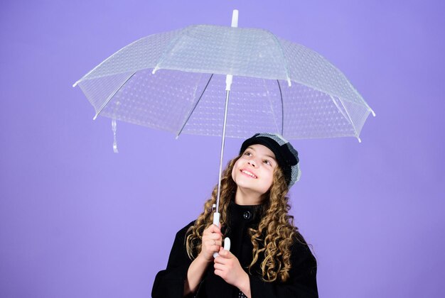 Fall season Enjoy rain concept Kids fashion trend Love rainy days Kid girl happy hold transparent umbrella Enjoy rainy weather with proper garments Waterproof accessories make rainy day fun