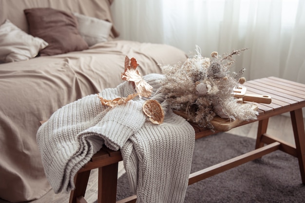 Осенняя атмосфера с деталями осеннего декора и вязанным свитером в комнате.