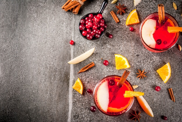 Fall and winter cold drinks, cranberry and orange holiday christmas punch with cinnamon, anise stars,  on black  copyspace top view