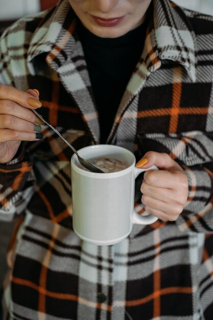 Fall winter cozy mood home day. Cold autumn or winter day. Warming mood. Woman drinking cocoa 