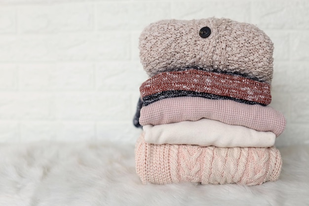 Fall winter season knitwear Stack of knitted warm pastel color sweaters with different knitting pat