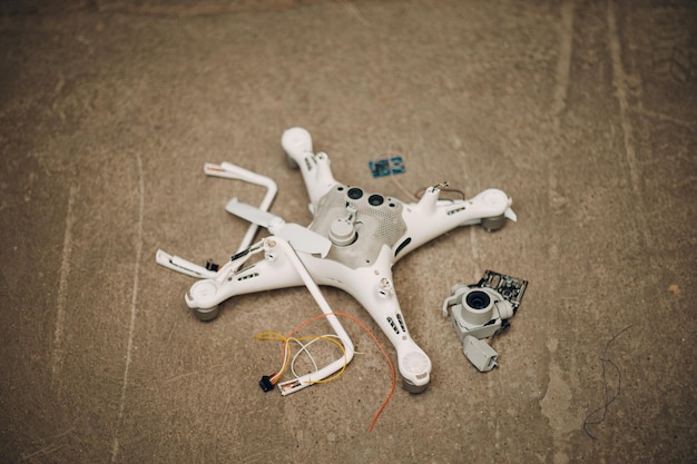 Un drone quadcopter caduto e danneggiato si è schiantato su un pavimento.