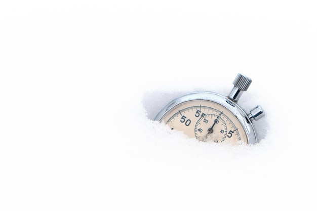 Fallen in the snow, in winter, stopwatch on a white background.