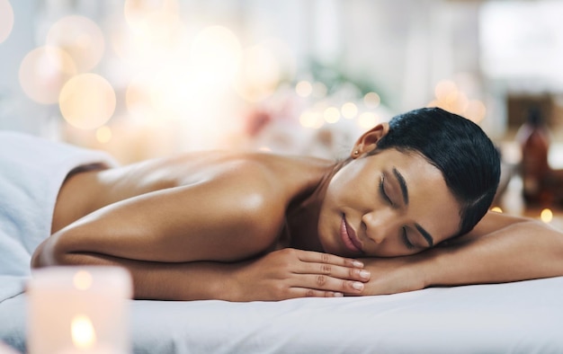 Falling asleep Shot of a relaxed an cheerful young woman getting a massage indoors at a spa