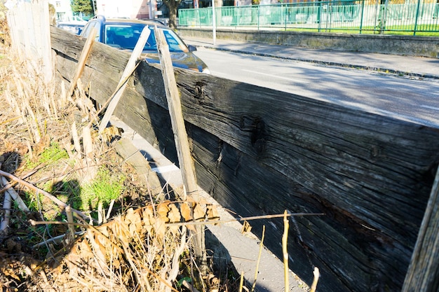 Photo falling down and damaged wooden fence in city