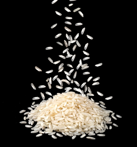 Falling dry rice grains isolated on black