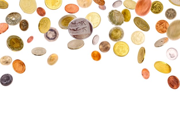 Photo falling and flying coins from all over the world isolated on white