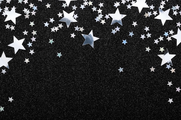 Falling silver stars confetti on black background