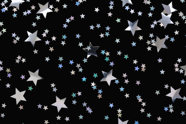 Photo falling silver stars confetti on black background