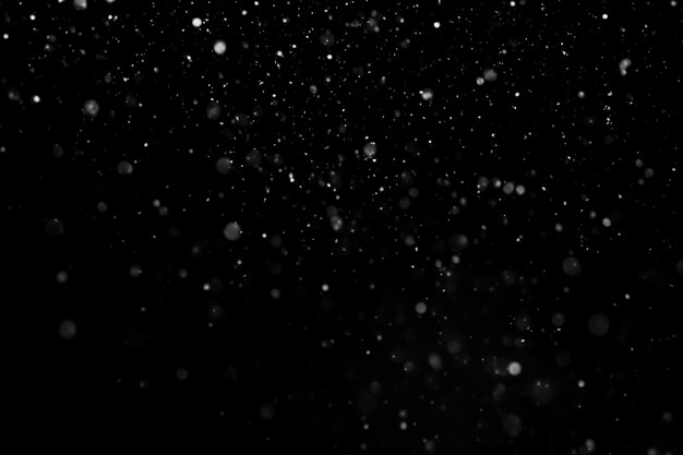 Falling snow isolated on black background