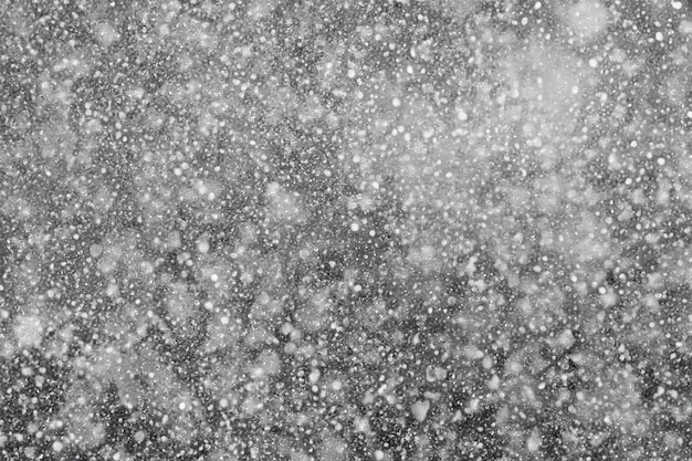 Falling snowflakes su uno sfondo nero migliora il tuo progetto con la consistenza nevosa usa come livello di schermo nell'editor di foto per l'integrazione della neve senza sforzo