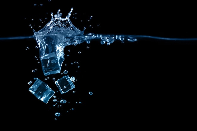 Falling to the water ice cubes on dark background