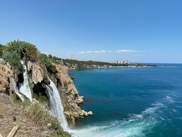 滝は約 40 m の高さから地中海に落ちる岩の崖から素晴らしい水で落ちます