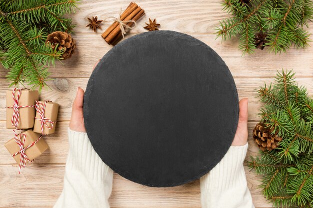 Famale hand hold Black slate round stone on wood