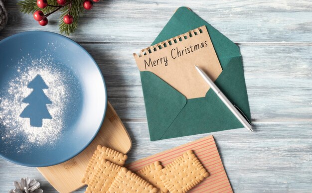 Famale hand writing a Christmas letter on wooden background