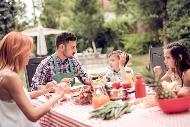 Familie aan het lunchen in de tuin